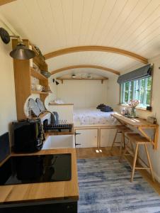 a kitchen with a table and a bed in a room at Cornish Valley Retreat in Bodmin +27 photos