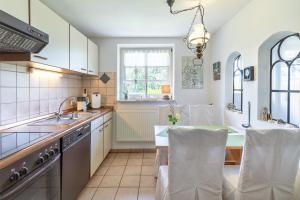 eine Küche mit Spüle und einem Tisch mit Stühlen in der Unterkunft Warftperle in Dagebüll