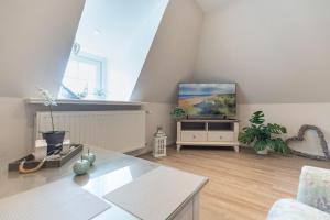 ein Wohnzimmer mit einem Fernseher auf einem Ständer in der Unterkunft Warftperle in Dagebüll