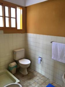 a bathroom with a toilet and a tub and a sink at Hostal Urbano in Tarija