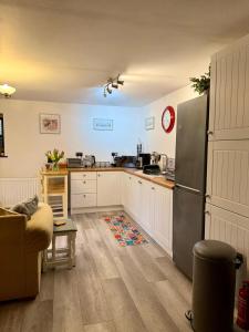 a kitchen with white cabinets and a stainless steel refrigerator at St Catherines, Winterborne Lodge in Blandford Forum