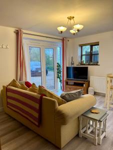 a living room with a couch and a tv at St Catherines, Winterborne Lodge in Blandford Forum