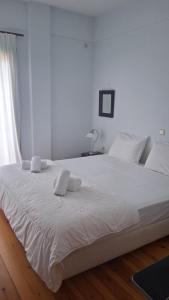 ein großes weißes Bett mit weißen Laken und ein Fenster in der Unterkunft Aeria View in Éva