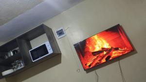 a fire in a fireplace in a kitchen with a microwave at H&Dluxe in Murangʼa