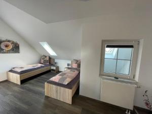 two beds in a room with a window at Apartments Reischl in Bergkirchen