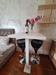 a white table with wine glasses and flowers on it at Apartment Harmony in Plužine