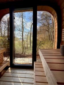 an open door to a room with a view of the woods at Ferienhaus TRAUM AM SEE mit Sauna und Whirlpool in Zislow