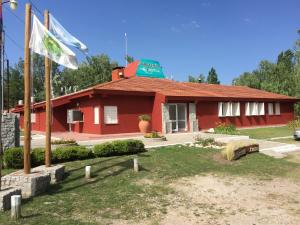 Un edificio rojo con una bandera delante. en Hosteria Renca, en Renca