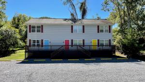 a white house with colorful doors in a driveway at The Blue Door at Sylva Home Base Apartments in Sylva