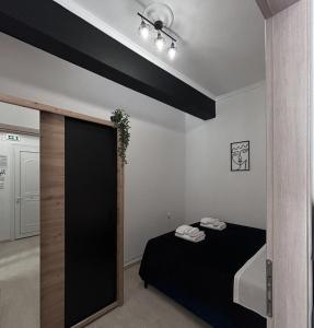a bedroom with a black bed and a black wall at Ammos in Kavála