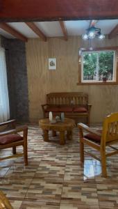 a living room with wooden furniture and a table at Cabañas La Piedra del Queso in Melipeuco
