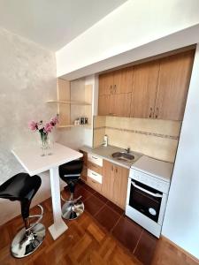 a kitchen with a sink and a table with two stools at Apartment Harmony in Plužine