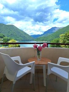 a table and chairs with a vase of flowers on a balcony at Apartment Harmony in Plužine