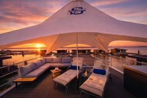 a large tent on a boat with couches and tables at Floatinghouse Seestern in Klitten