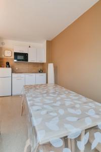 a dining room with a table and a kitchen at Cosy app near sea in Cabourg