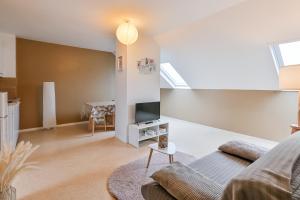 a living room with a couch and a tv at Cosy app near sea in Cabourg