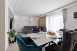 a dining room and living room with a table and chairs at HoUsE MILETIC in Solin
