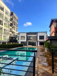 a swimming pool in front of a building at Serenity suites in Nairobi