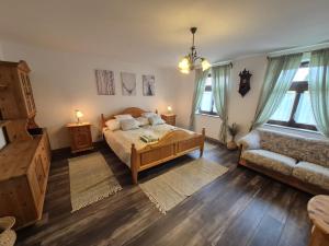 a bedroom with a bed and a couch and windows at Gerendás in Szilvásvárad