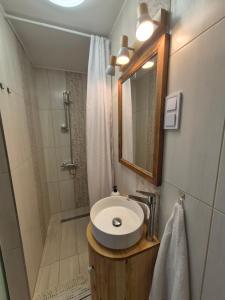 a bathroom with a sink and a shower with a mirror at Gerendás in Szilvásvárad +2 photos
