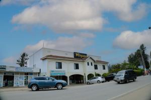 a blue car parked in front of a building at Migano Hotel in Ruhengeri +16 photos