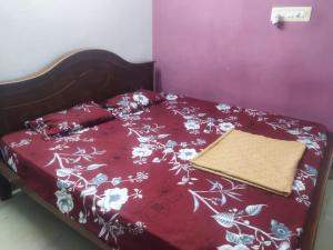 a bed with a red bedspread with flowers on it at WooLiv in Coimbatore