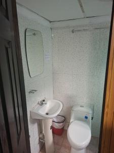 a small bathroom with a sink and a toilet at Casa Del Mar Pedasí in Pedasí Town +14 photos