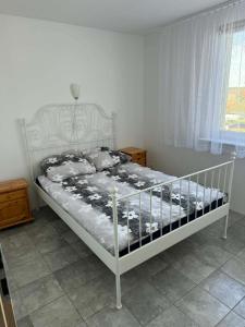 a white bed in a bedroom with a window at Rodzinna Przystań Arkadia in Dominice