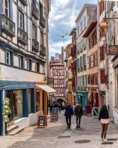 a group of people walking down a city street at Maisonnette Cosy Villa Ajna in Bayonne