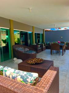 a living room with couches and a table with a dog at Casa Brisa do Mar in Cabedelo