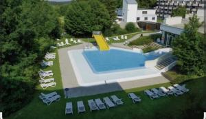 an overhead view of a pool with chairs and a resort at Ferienwohnung Molly inclusive Hallenbad, Sauna, Fitnessstudio und Aussenpool in Sankt Englmar