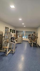 a gym with rows of treadmills and chairs at Ferienwohnung Molly inclusive Hallenbad, Sauna, Fitnessstudio und Aussenpool in Sankt Englmar