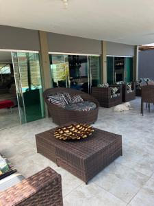 a living room with two wicker chairs and a table at Casa Brisa do Mar in Cabedelo