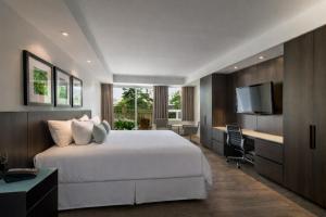 a bedroom with a large white bed and a desk at Taboo Muskoka in Gravenhurst