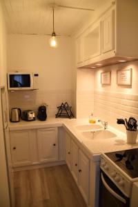 a white kitchen with a sink and a microwave at Gîte NAO in Serves-sur-Rhône +22 photos