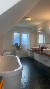a large white bathroom with two sinks and a tub at Bright Rooms with WiFi , Terrace between Freiburg and France , private Zimmer in Freiburg im Breisgau