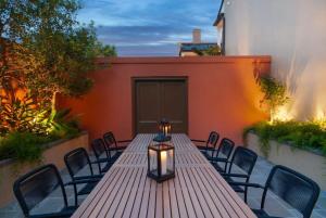 a wooden table with chairs and a light on a patio at Historic CBD Townhomes with Courtyard in New Orleans