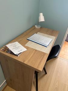 a wooden desk with a lamp and papers on it at Włocławek Norwida in Włocławek