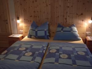a bedroom with two beds with blue and white pillows at Bio-Urlaubshof Dansbach in Spital am Pyhrn