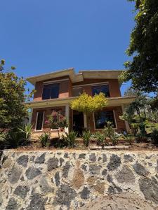 a house with a stone wall in front of it at Brisa Campestre in Tomatlán