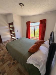 a bedroom with a bed with red curtains and a window at Brisa Campestre in Tomatlán