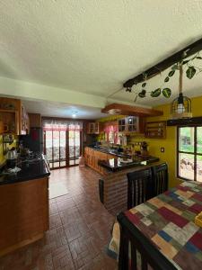 a kitchen with yellow walls and a table in a room at Brisa Campestre in Tomatlán
