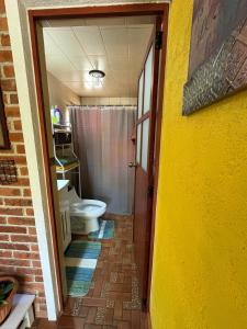 a bathroom with a toilet and a sink and a door at Brisa Campestre in Tomatlán +49 photos