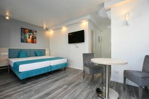 a bedroom with a bed and a table and chairs at City-Hotel Zuffenhausen - Apartments in Stuttgart