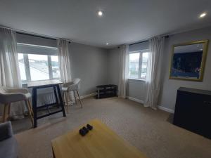 a living room with a table and some windows at Greenmount - 1 Bed Apartment in Naas