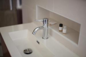 a bathroom sink with a faucet and a mirror at The Corner Tivoli in Tivoli +22 photos