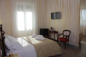 a bedroom with a bed and a chair and a television at The Corner Tivoli in Tivoli