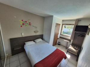 a bedroom with a bed with a flower arrangement on the wall at Hôtel Le Floreal in Trèbes +44 photos