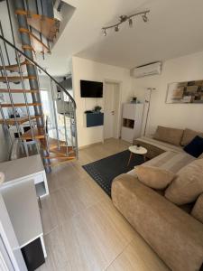 a living room with a couch and a stair case at Holiday house Matej in Vir