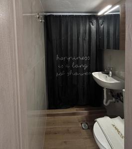 a bathroom with a black shower curtain and a sink at Ammos in Kavála +18 photos
